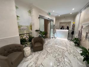 a lobby with a marble floor with chairs and a counter at Hotel Le Petit in Rome