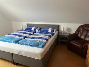 ヴェルドゥムにあるLandhaus Heykenのベッド1台(青と白の毛布、椅子付)