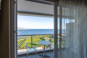 balcón con mesa, sillas y vistas al océano en Adenya Hotel & Resort Halal All Inclusive, en Avsallar