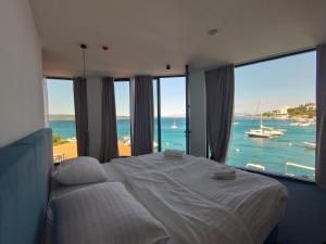a bedroom with a large bed with a view of the ocean at Hotel Millenium deluxe in Selce
