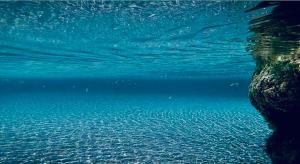 a large body of blue water with a rock at Stabilimento Lido Burrone in Favignana