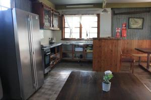 a kitchen with a refrigerator and a stove at Lovedale Cottages Hunter Valley in Lovedale