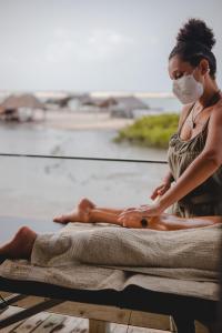 a woman in a face mask sitting on a towel at Casa Uca in Guriú