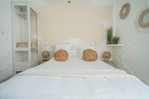 a white bedroom with a large white bed with pillows at Hôtel Le Méditerranée in Hyères