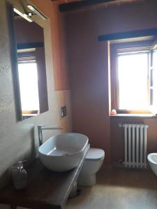 a bathroom with a tub and a toilet and a mirror at Casolare il Moro in Monte San Savino