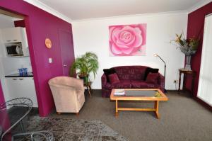 - un salon avec un canapé violet et une table dans l'établissement Beachfront Apartments, à Narooma