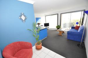 una oficina con una silla roja y una pared azul en Beachfront Apartments, en Narooma