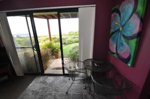 Beachfront Apartments في ناروما: غرفة بطاولتين ولوحة على الحائط