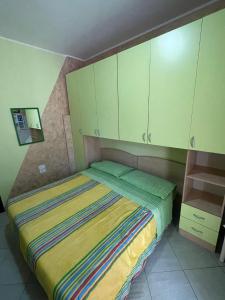 a small bedroom with a bed with green cabinets at B&B La Palma in Petacciato