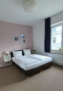 Schlafzimmer mit einem großen Bett und einem Fenster in der Unterkunft Gästehaus bed & kitchen in Schleswig