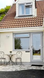 a patio with two chairs and a table in front of a house at The Nook @ Drop Anchor in Portishead