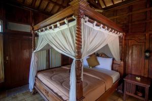 A bed or beds in a room at Ganesha Ubud Inn
