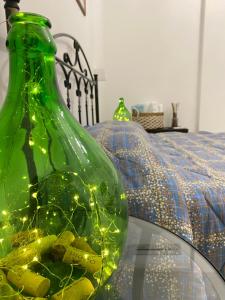 un vaso di vetro verde con luci su un letto di Donna Filomena a Monopoli