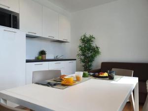 a white kitchen with a white table with food on it at Superior Beach Aparthotel in Lido di Jesolo