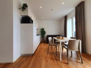 a kitchen and a dining room with a table and chairs at Superior Beach Aparthotel in Lido di Jesolo