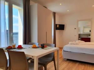 a room with a bed and a table and a bed and a bedroom at Superior Beach Aparthotel in Lido di Jesolo