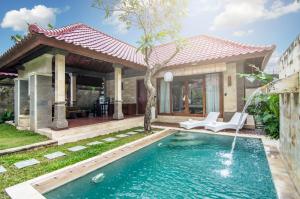 a swimming pool in front of a house at Bali Prime Villas in Seminyak