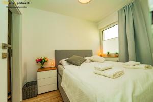 En eller flere senge i et værelse på Baltic Apartments - Stawa Młyny