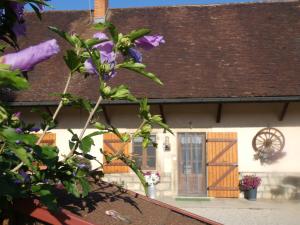 a house with a purple flower in front of it at La mare aux grenouilles in Bruailles