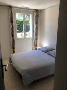 une chambre avec un lit blanc et une fenêtre dans l'établissement Maison au calme avec parking en petite Camargue, à Beauvoisin