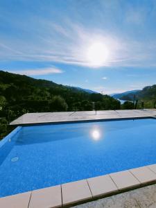 a large blue swimming pool with a mountain in the background at Casa da Benda in Caniçada
