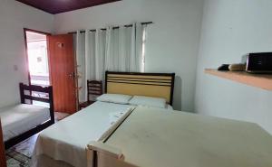 a small bedroom with a bed and a window at Pousada Ninho da Coruja in Arraial do Cabo