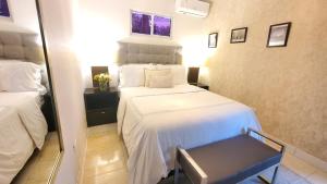 a hotel room with a bed, chair, and nightstand at Hotel Santa Clara in San Fernando de Monte Cristi