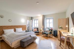 1 dormitorio con 1 cama, escritorio y sillas en Altstadthotel Eibsen, en Otterndorf