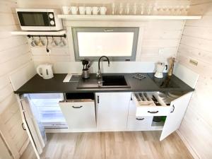a kitchen in a tiny house with a sink at LABALAND in Gąski