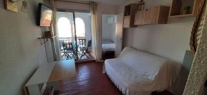 um quarto com uma cama, uma mesa e uma varanda em Studio de vacances 3eme et dernier étage vue Marina em Le Barcarès