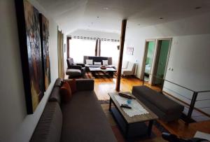ein Wohnzimmer mit einem Sofa und einem Tisch in der Unterkunft Rural villa Private pool, BBQ, court ,20' airport in Nea Kallikratia