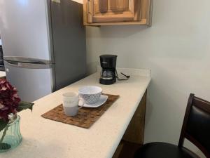 eine Küchentheke mit zwei Tassen und einer Kaffeemaschine in der Unterkunft Musgrave AnneX- comfy 1 bedroom apartment on the ground floor in Kingston