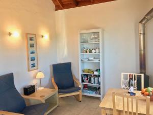 ein Wohnzimmer mit einem Tisch und einem blauen Stuhl in der Unterkunft Casa Lucia in Puntagorda