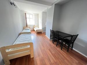 a room with a piano and a table and chairs at Hostel WOKU in Świebodzice