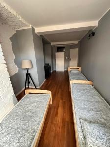 szereg łóżek w pokoju z drewnianą podłogą w obiekcie Hostel WOKU w mieście Świebodzice
