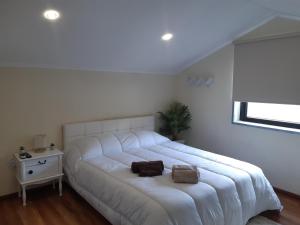 1 cama blanca grande en un dormitorio blanco en Quinta da Àgua en Torre de Moncorvo