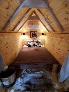 ein Schlafzimmer in einem Blockhaus mit einem Bett darin in der Unterkunft Le Kota Etable in La Chapelle