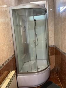 a shower with a glass door in a bathroom at Hotel Milana in Orenburg