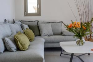 a living room with a gray couch with pillows and a table at Faenna - Zeus Blue Villas, Kefalonia in Kefallonia