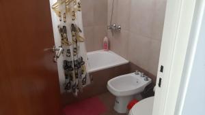 Un baño con lavabo, inodoro y cortina de ducha. en ROSARINO, en Rosario