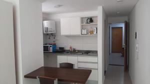 Una cocina con gabinetes blancos y una mesa de madera. en ROSARINO, en Rosario