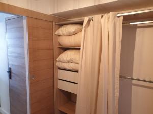a bedroom with a closet with a curtain and pillows at Résidence Alpinéa Mottaret, 3 à 5pers in Méribel
