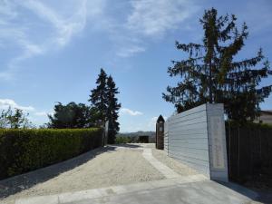 un vialetto con una recinzione bianca e un albero di Agriturismo bottega di Rosanna a Castagnole Lanze