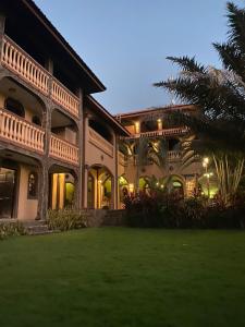 ein großes Haus mit Rasen davor in der Unterkunft Hotel El Reith Lake in Granada