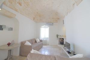 a living room with a couch and a tv at La Poma in Ostuni