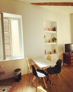 - une table et des chaises dans une chambre avec fenêtre dans l'établissement Vaste loft plein de charme au cœur de Marseille, à Marseille