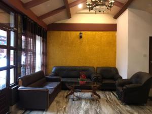 a living room with two couches and a table at Hotel The Narayani Continental in Gangtok