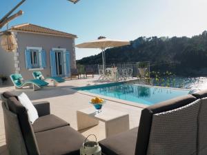 a swimming pool with chairs and an umbrella on a patio at Assos View in Asos