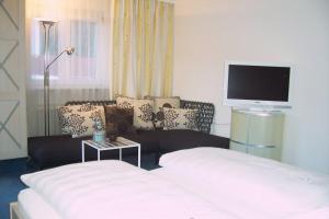 ein Hotelzimmer mit einem Bett und einem TV in der Unterkunft Gästehaus Margarete in Bad Wiessee