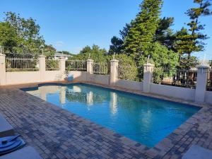 a swimming pool in a yard with a fence at Serengeti selfcatering apartments Perfect Stay in Bellville
